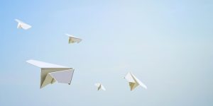 Achtergrond lichtblauw met papieren vliegtuigjes